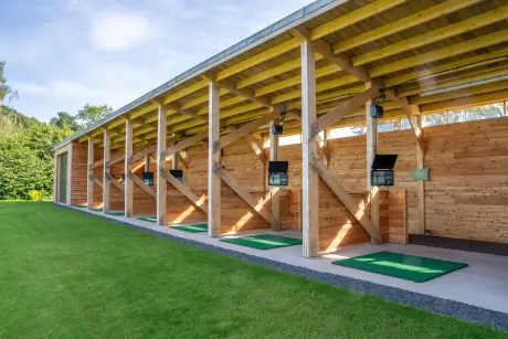 A modern driving range showcasing grass practice areas and digital monitors for golfers.