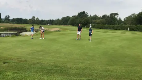 Group enjoying a round of golf on a lush green course with scenic views.