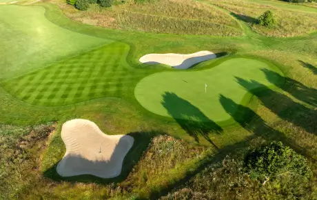 Aerial view of a lush golf course with manicured greens and sand traps.